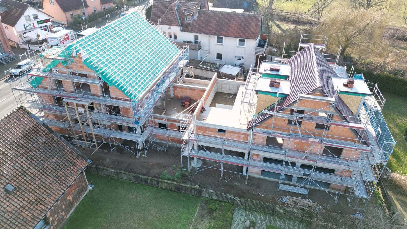 Aufstockung im Bestand: eingerüstete Gebäude mit neuem Dachstuhl