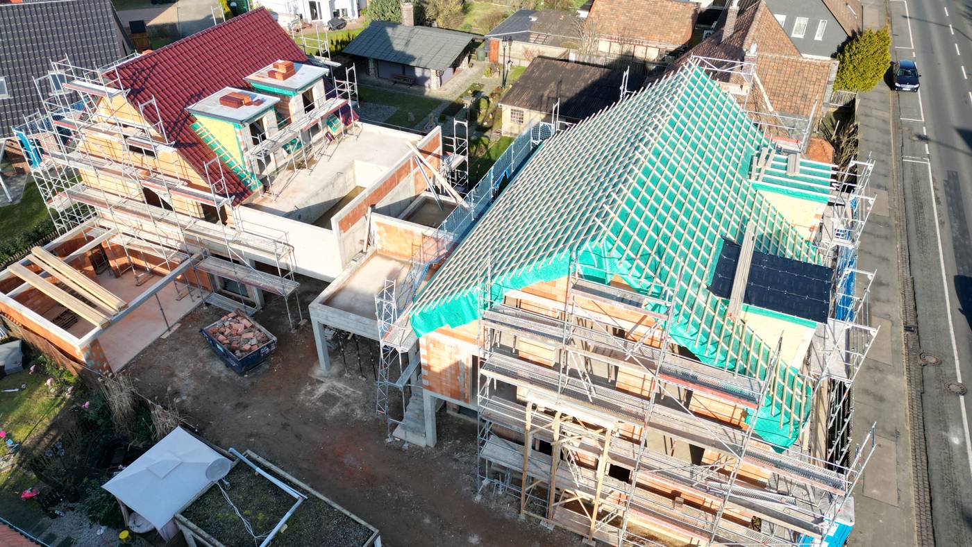 Zwei Bestandsgebäude während Aufstockung und Dachneubau